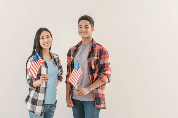 Young people with USA flags on light background — Stock Photo, Image