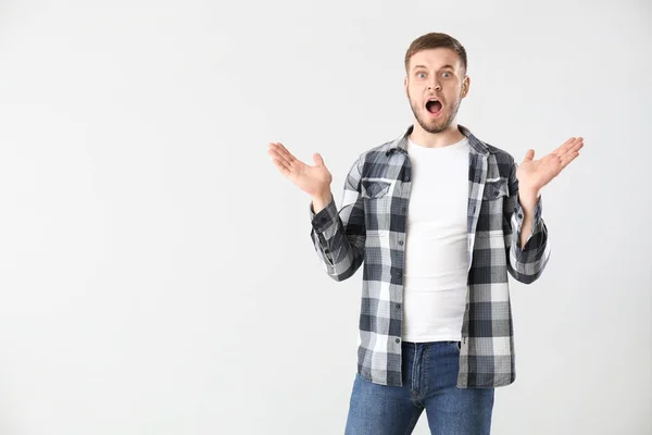 Shocked young man on light background — Stock Photo, Image