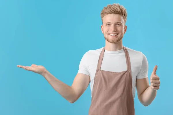 Handsome male chef showing something on color background — Stock Photo, Image