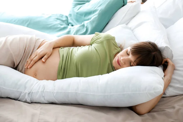 Hamile yastığı evde uyuyan genç hamile kadın — Stok fotoğraf