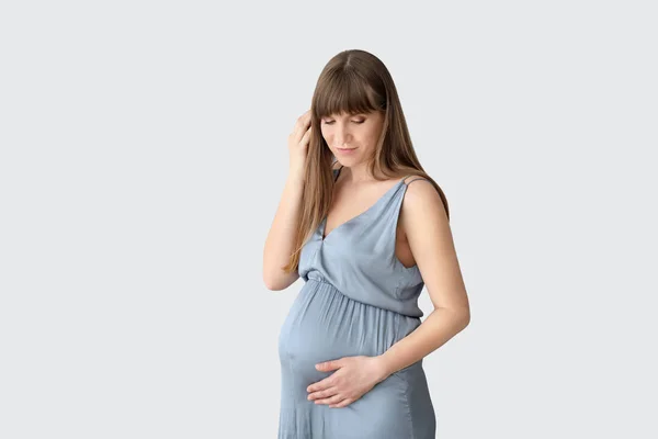 Junge schwangere Frau auf hellem Hintergrund — Stockfoto
