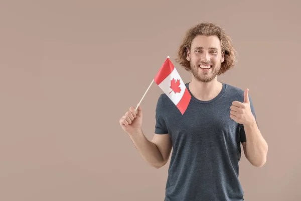 Jeune homme avec drapeau canadien sur fond de couleur — Photo