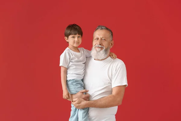 Carino bambino con nonno su sfondo di colore — Foto Stock
