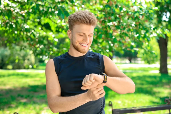 Sporty young man checking his pulse outdoors — Stock Photo, Image