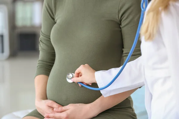 Läkare undersöker gravid kvinna på kliniken — Stockfoto