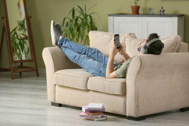 Evde sesli kitap dinleyen genç adam