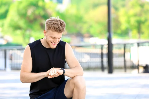 Sporty young man checking his pulse outdoors — Stock Photo, Image