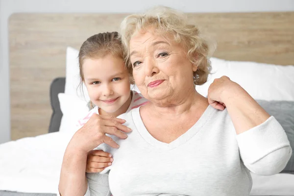 Cute little girl with grandmother at home — Stock Photo, Image