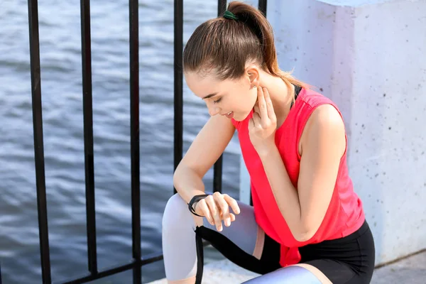 Sporty young woman checking her pulse outdoors — Stock Photo, Image