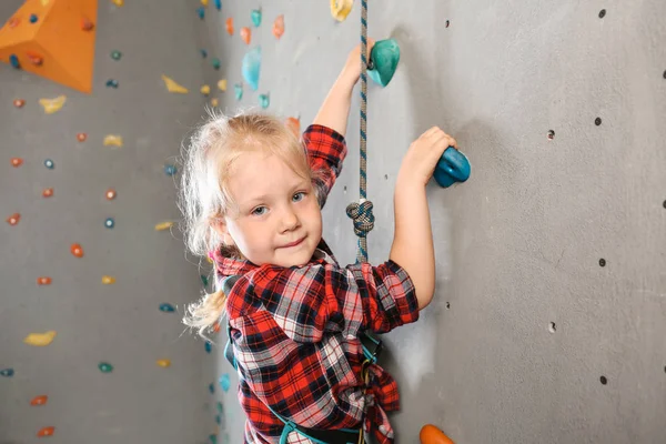 Mała dziewczynka wspinaczkowa ściana w siłowni — Zdjęcie stockowe