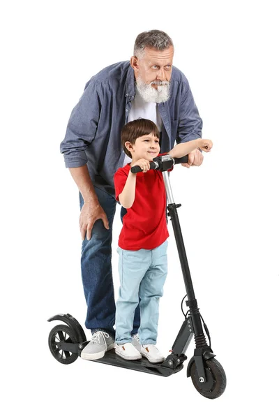 Mignon petit garçon avec coup de pied scooter et son grand-père sur fond blanc — Photo