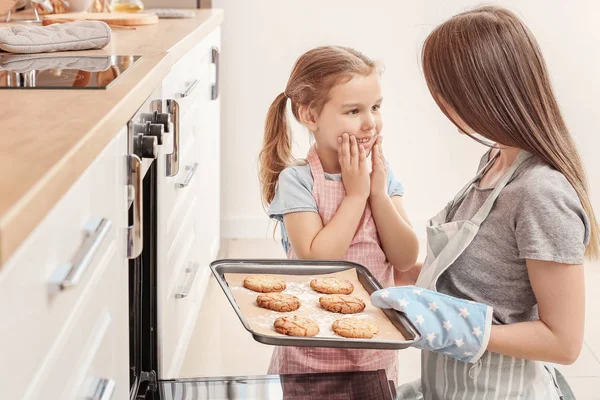 Little girl and her mother baking cookies in kitchen — Stock Photo, Image