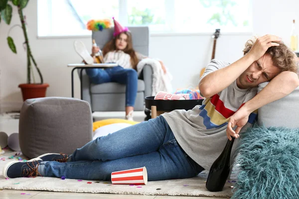 Jovem com ressaca após festa em casa — Fotografia de Stock