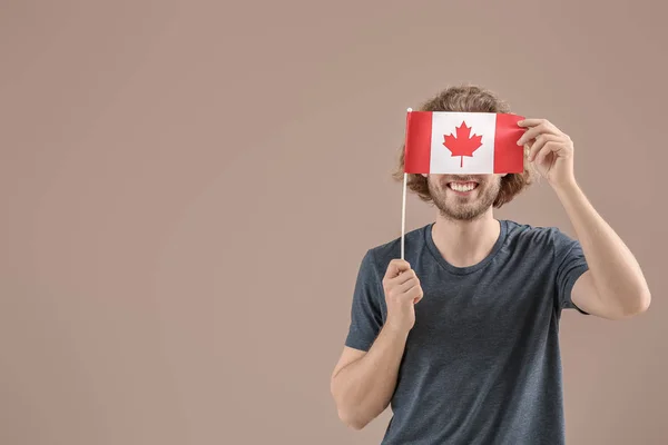 Giovane uomo con bandiera canadese su sfondo a colori — Foto Stock