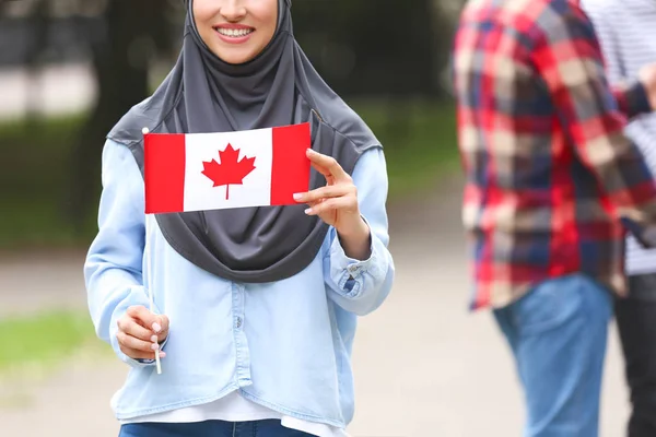 户外悬挂加拿大国旗的女穆斯林学生 — 图库照片