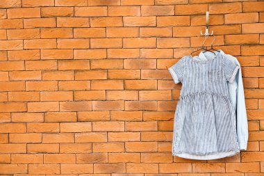 Tuğla duvarda giysi ile Askılar