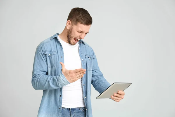 Dühös fiatalember a Tablet Computer fény háttér — Stock Fotó