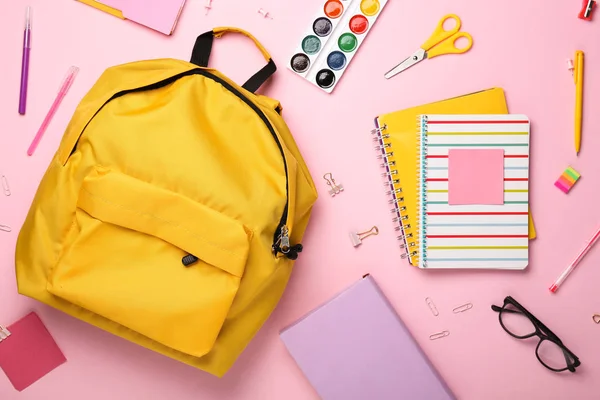 Plecak szkolny i papeteria na kolorowym tle — Zdjęcie stockowe