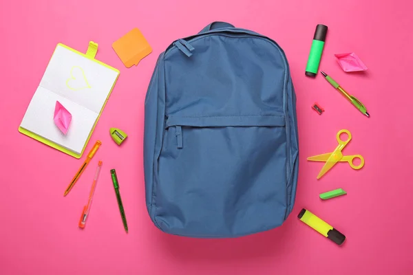 School backpack and stationery on color background — Stock Photo, Image