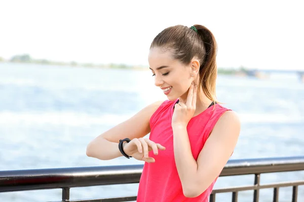 Deportiva joven mujer chequeando su pulso al aire libre — Foto de Stock