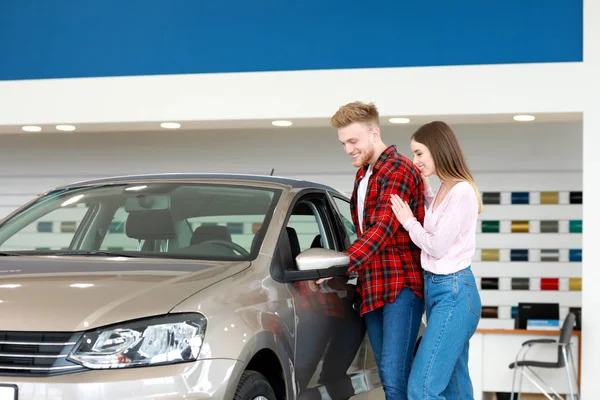 Couple choosing new car in salon — Stock Photo, Image