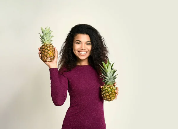 明るい背景にパイナップルを持つ幸せなアフリカ系アメリカ人女性の肖像画 — ストック写真