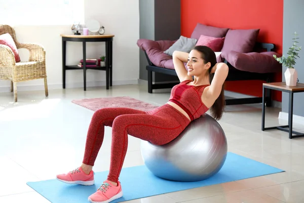 Mujer joven haciendo ejercicio con fitball en casa —  Fotos de Stock