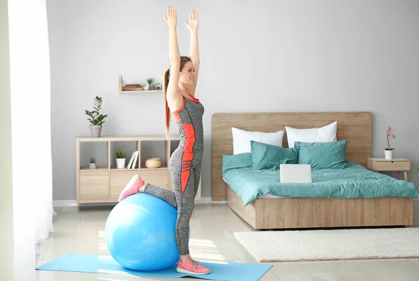 Jovem fazendo exercício com fitball em casa — Fotografia de Stock