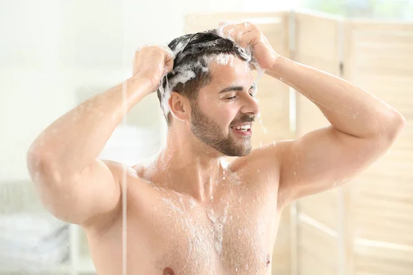 Hombre guapo lavando el cabello en casa — Foto de Stock