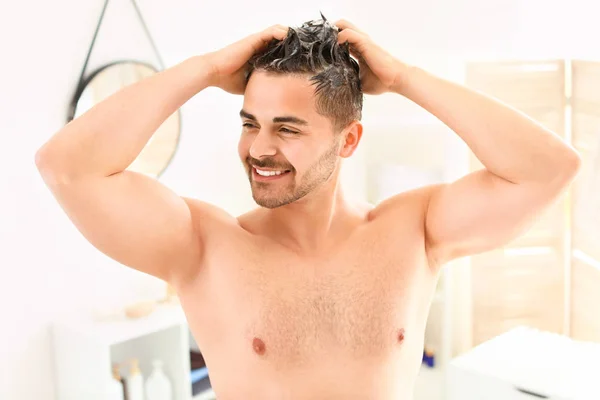 Handsome man washing hair in bathroom — Stock Photo, Image