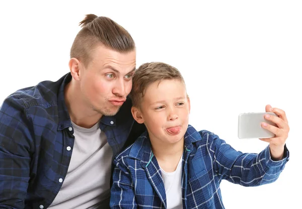 Retrato de pai engraçado e filho tomando selfie no fundo branco — Fotografia de Stock