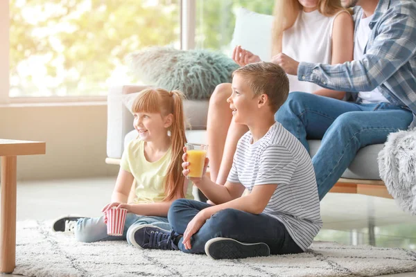 Glad familj tittar på TV hemma — Stockfoto