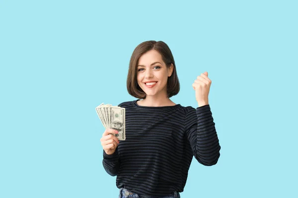 Happy young woman with money on color background — Stock Photo, Image