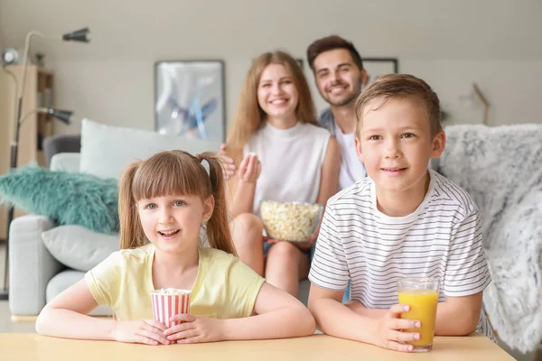 Glad familj tittar på TV hemma — Stockfoto