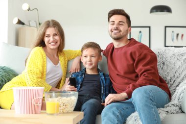 Evde televizyon izleyen mutlu bir aile.