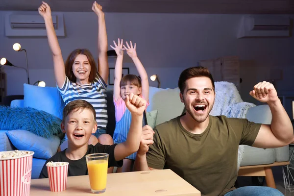 Família feliz assistindo esportes na TV em casa — Fotografia de Stock