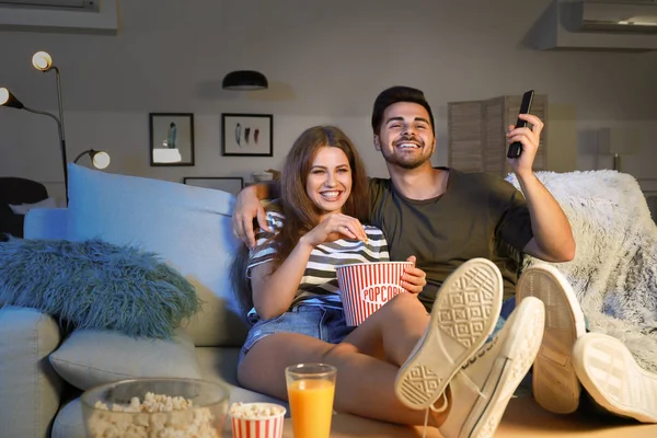 Szczęśliwa para ogląda telewizję wieczorem — Zdjęcie stockowe