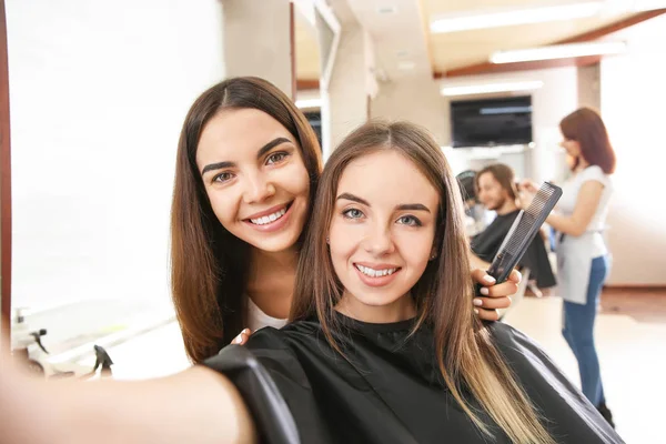 Young woman taking selfie with her hairdresser in salon — Stock Photo, Image