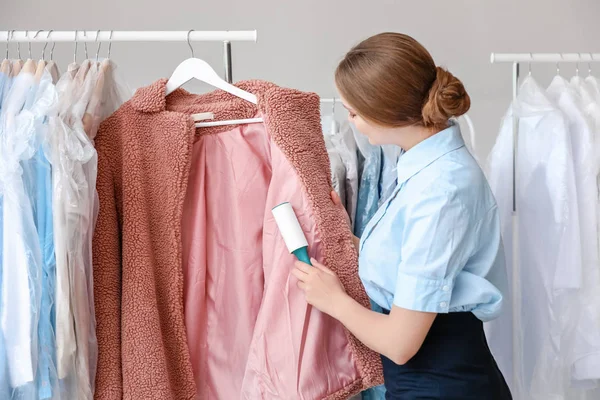 Woman removing dirt from clothes in modern dry-cleaner's — Stock Photo, Image