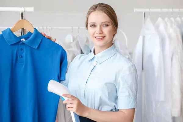 Vrouw stomen kleren in moderne Dry-Cleaner — Stockfoto