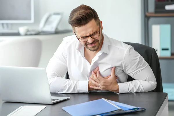 Young businessman having heart attack in office — Stock Photo, Image