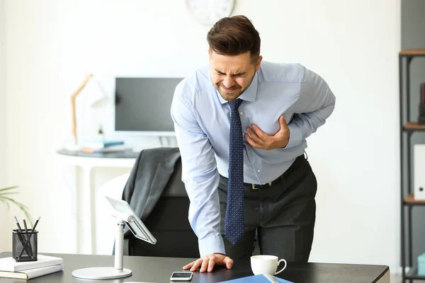 Joven hombre de negocios teniendo un ataque al corazón en la oficina — Foto de Stock