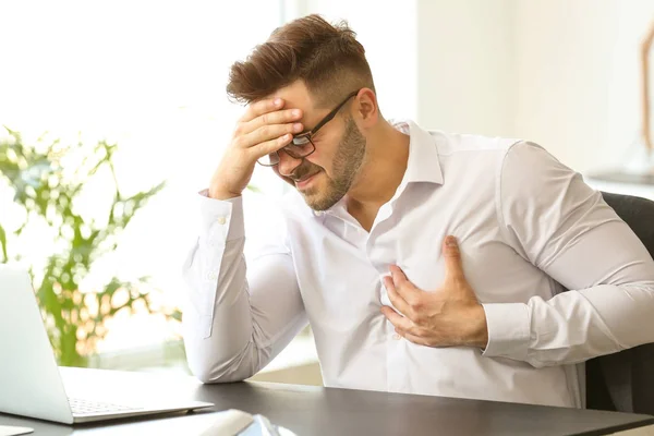 Young businessman having heart attack in office — Stock Photo, Image