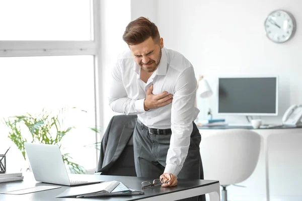 Молодий бізнесмен має серцевий напад в офісі — стокове фото