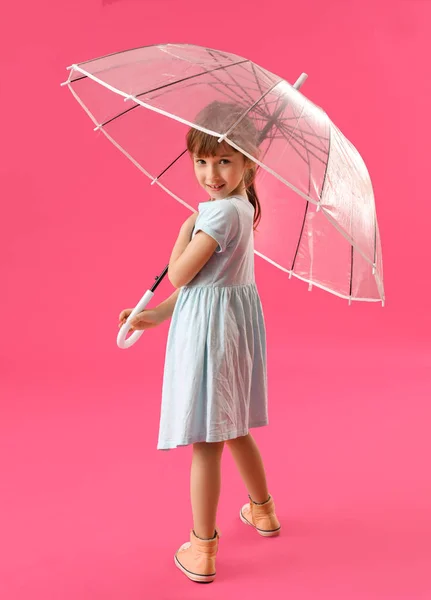 Cute little girl with umbrella on color background — Stock Photo, Image
