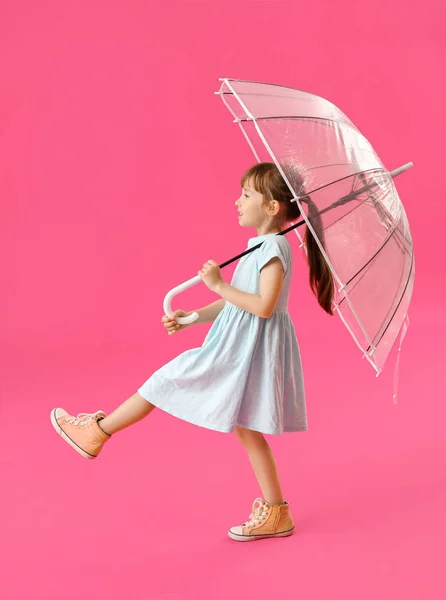 色の背景に傘を持つかわいい女の子を行く — ストック写真