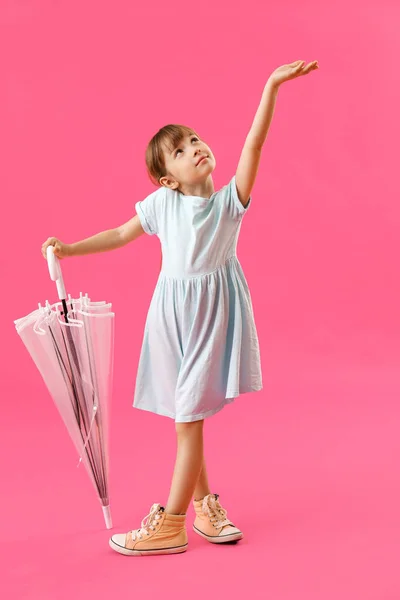 stock image Cute little girl with umbrella on color background