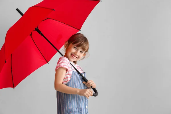 Cute little girl with umbrella on light background — Stock Photo, Image