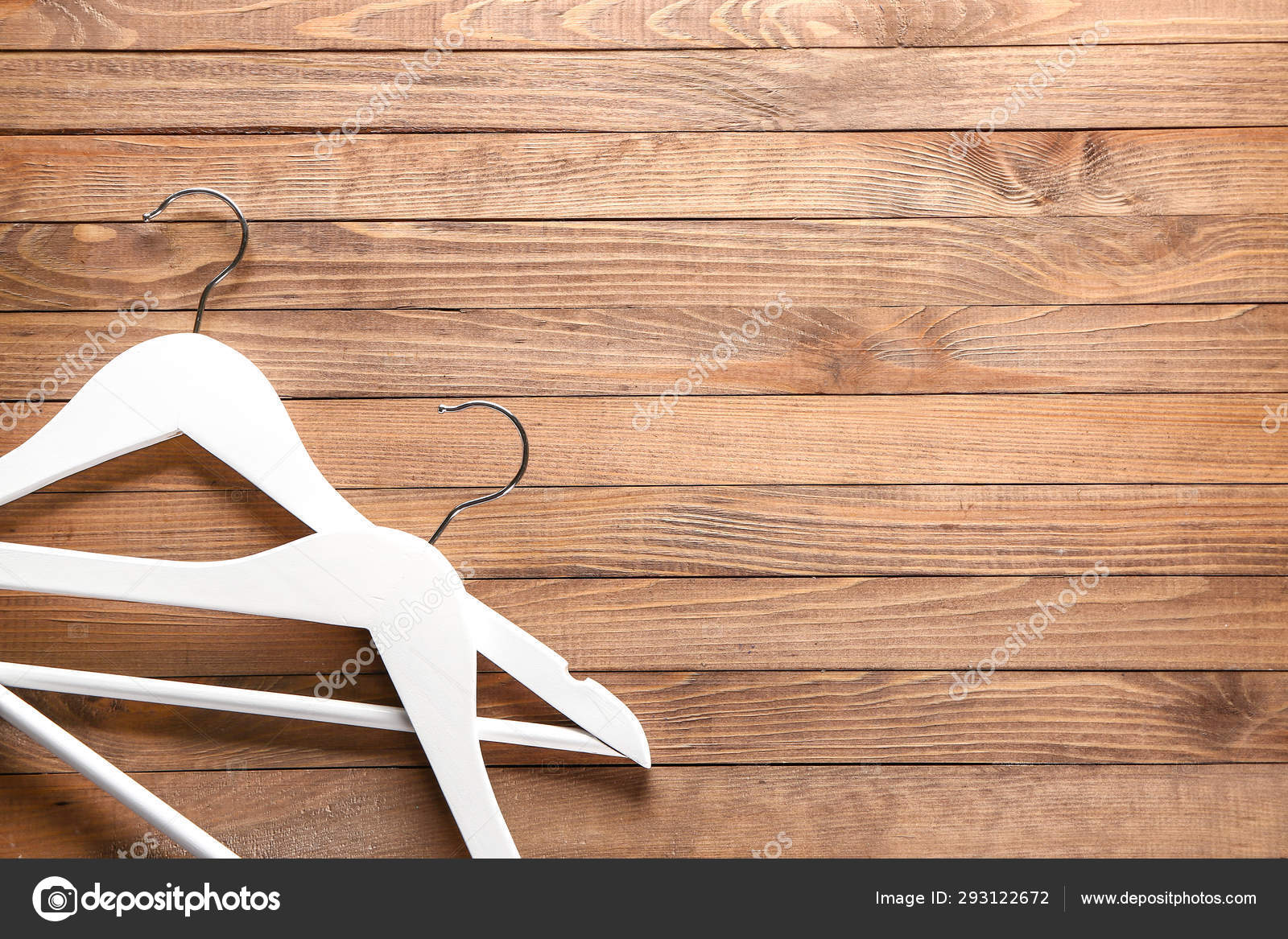 Clothes hangers on wooden background Stock Photo by ©serezniy 293122672