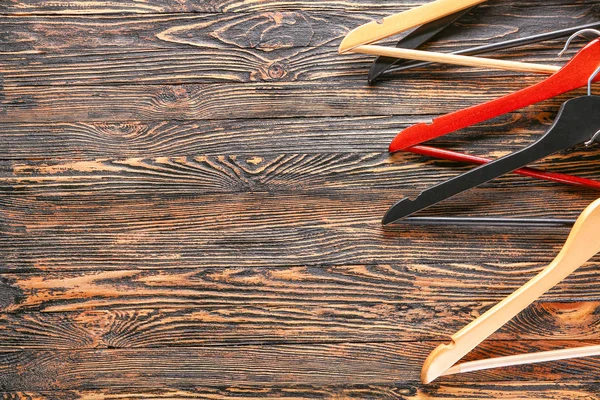 Many clothes hangers on wooden background